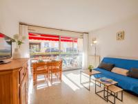 a living room with a blue couch and a table at Apartment Le Grand Large-1 by Interhome in Sainte-Maxime