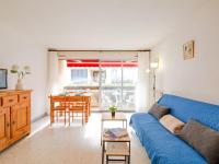 a living room with a blue couch and a table at Apartment Le Grand Large-1 by Interhome in Sainte-Maxime