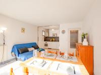 a living room with a table and a blue couch at Apartment Le Grand Large-1 by Interhome in Sainte-Maxime