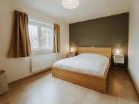 a bedroom with a bed and two windows at Apartment Rodenbach by Interhome in De Haan