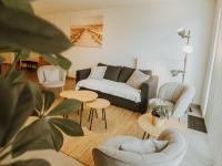 a living room with a couch and chairs and tables at Apartment Rodenbach by Interhome in De Haan