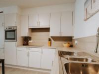 a kitchen with white cabinets and a sink at Apartment Rodenbach by Interhome in De Haan