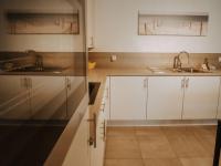 a kitchen with white cabinets and a sink at Apartment Rodenbach by Interhome in De Haan