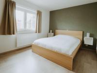 a bedroom with a large bed and a window at Apartment Rodenbach by Interhome in De Haan