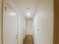 a hallway with white walls and a white door at Apartment Rodenbach by Interhome in De Haan