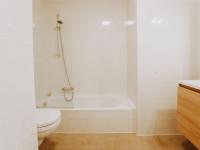 a white bathroom with a toilet and a bath tub at Apartment Rodenbach by Interhome in De Haan