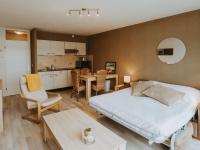 a bedroom with a bed and a table and a kitchen at Studio Zeeduin by Interhome in Bredene