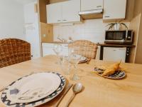 a wooden table with plates and wine glasses on it at Studio Zeeduin by Interhome in Bredene