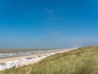 a beach with a row of umbrellas and the ocean at Studio Zeeduin by Interhome in Bredene