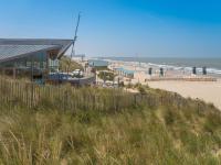 a view of a beach with a building and the ocean at Studio Zeeduin by Interhome in Bredene