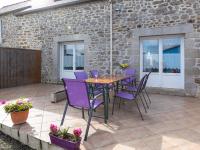 a patio with a wooden table and purple chairs at Holiday Home Coquelicot by Interhome in Saint-Méloir-des-Ondes