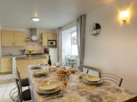 a dining room table with plates and dishes on it at Holiday Home Coquelicot by Interhome in Saint-Méloir-des-Ondes