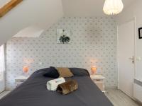 a bedroom with a large bed with two night stands at Holiday Home Coquelicot by Interhome in Saint-Méloir-des-Ondes
