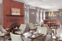a restaurant with tables and chairs and a brick wall at Portland Regency Hotel & Spa in Portland