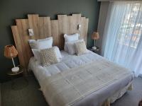 a bedroom with a large bed with white sheets and pillows at Hôtel Restaurant BO &amp; MIA in La Baule