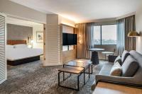 a hotel room with a bed and a couch and a table at Sheraton Suites Wilmington Downtown in Wilmington
