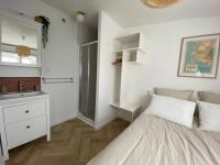 a bedroom with a bed and a sink and a mirror at Studio au calme St Marc sur Mer in Saint-Nazaire