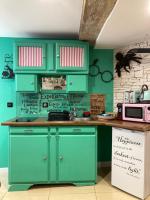 a kitchen with green cabinets and a green wall at Les sorciers, la Diligence St Jean de Losne in Saint-Jean-de-Losne