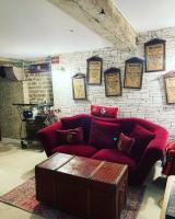 a living room with a red couch and a brick wall at Les sorciers, la Diligence St Jean de Losne in Saint-Jean-de-Losne