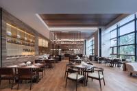 uma sala de jantar com mesas, cadeiras e janelas em Wenzhou Marriott Hotel em Wenzhou