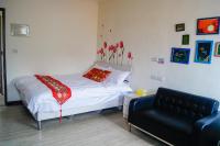 a bedroom with a bed and a black couch at Ding Ding Homestay in Jinhu