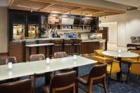 a bar with tables and chairs in a restaurant at Courtyard by Marriott Glassboro Rowan University in Glassboro