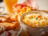 川崎市にあるダイワロイネットホテル川崎のテーブルの上にご飯の入ったボウルと食べ物の皿が置かれている