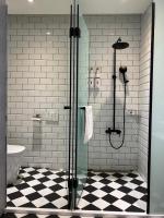 a bathroom with a shower and a black and white floor at Cingjing Florence Resort Villa in Ren&#39;ai