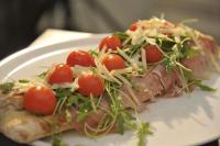 a white plate with a piece of pizza with tomatoes on it at O'Presidente B&B in Gragnano