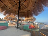 a beach with chairs and umbrellas on the beach at Mangroovy Seafront condo - Great Kite Surfing in Hurghada