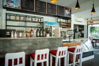a bar with four white chairs and a counter at Sala Siem Reap Hotel in Siem Reap