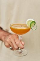 Mangroove Bay Boutique Hostel في بانُوويدانغْ: شخص يحمل مشروبًا مع ليمونة في الأعلى