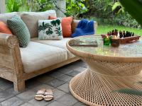 The White Villas Ubud في أوبود: فناء مع أريكة رتان وطاولة زجاجية