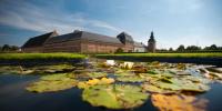 a pond with lily pads in front of a building at Cosy appartement Kur 62 Hasselt in Hasselt