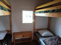 a bedroom with two bunk beds and a window at CAMPING DE LA CHALARONNE in Saint-Didier-sur-Chalaronne