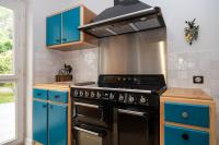 a kitchen with blue cabinets and a stove at Propriete spacieuse a Saint Trojan Vue mer in Saint-Trojan-les-Bains