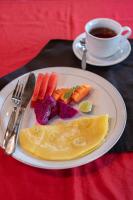 a plate of food with carrots and a cup of coffee at Bamboo Ubud Hostel in Ubud