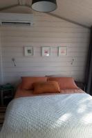 a bed with orange pillows in a bedroom at Chalet la lande in Ondres