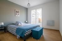 a bedroom with a bed with a blue foot stool at Charmant pavillon bordelais (logement entier) in Saint-Médard-en-Jalles