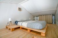 a bed sitting on a wooden platform in a room at Charmant pavillon bordelais (logement entier) in Saint-Médard-en-Jalles