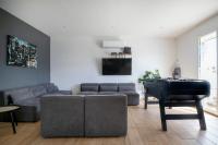 a living room with a couch and a piano at Charmant pavillon bordelais (logement entier) in Saint-Médard-en-Jalles