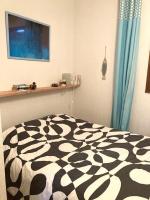 a bedroom with a black and white comforter on a bed at small house 6p in bormes, quiet , hill-view in Bormes-les-Mimosas