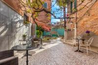 a patio with tables and chairs and a brick building at Hotel Casa Boccassini in Venice