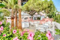 eine Terrasse mit Tischen, Stühlen und rosa Blumen in der Unterkunft The Pink Elephant Hotel in S'Agaró