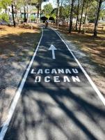 a road with an arrow sign in a park at Cocon front de mer côté cour in Lacanau