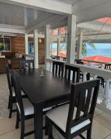 een eetkamer met een zwarte tafel en stoelen bij Los Delfines Hotel & Dive Center in Little Corn Island