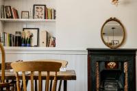 uma sala de jantar com uma mesa e um espelho em The Heathcock Boutique Hotel - Room 1 em Cardiff