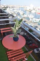 a plant on a red table on a balcony with a marina at Studio, vue exceptionnelle sur le port de pêche in Les Sables-d&#39;Olonne