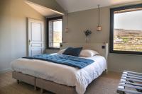 a bedroom with a large bed and two windows at Château de Pierreclos in Pierreclos
