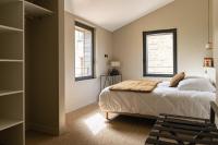 a bedroom with a bed and two windows at Château de Pierreclos in Pierreclos